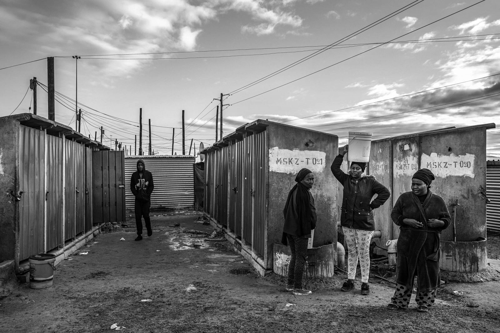 Banheiros públicos em péssimas condições e locais para captação de água na "township" de Khayelitsha, na Cidade do Cabo