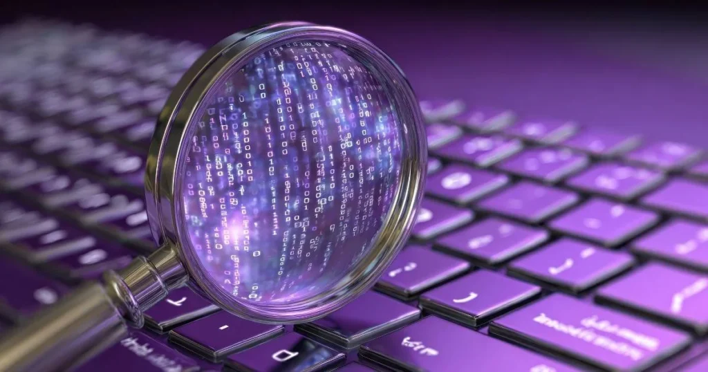 magnifying glass revealing binary code purple keyboard